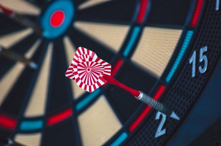 A dart just off the bullseye of a dartboard