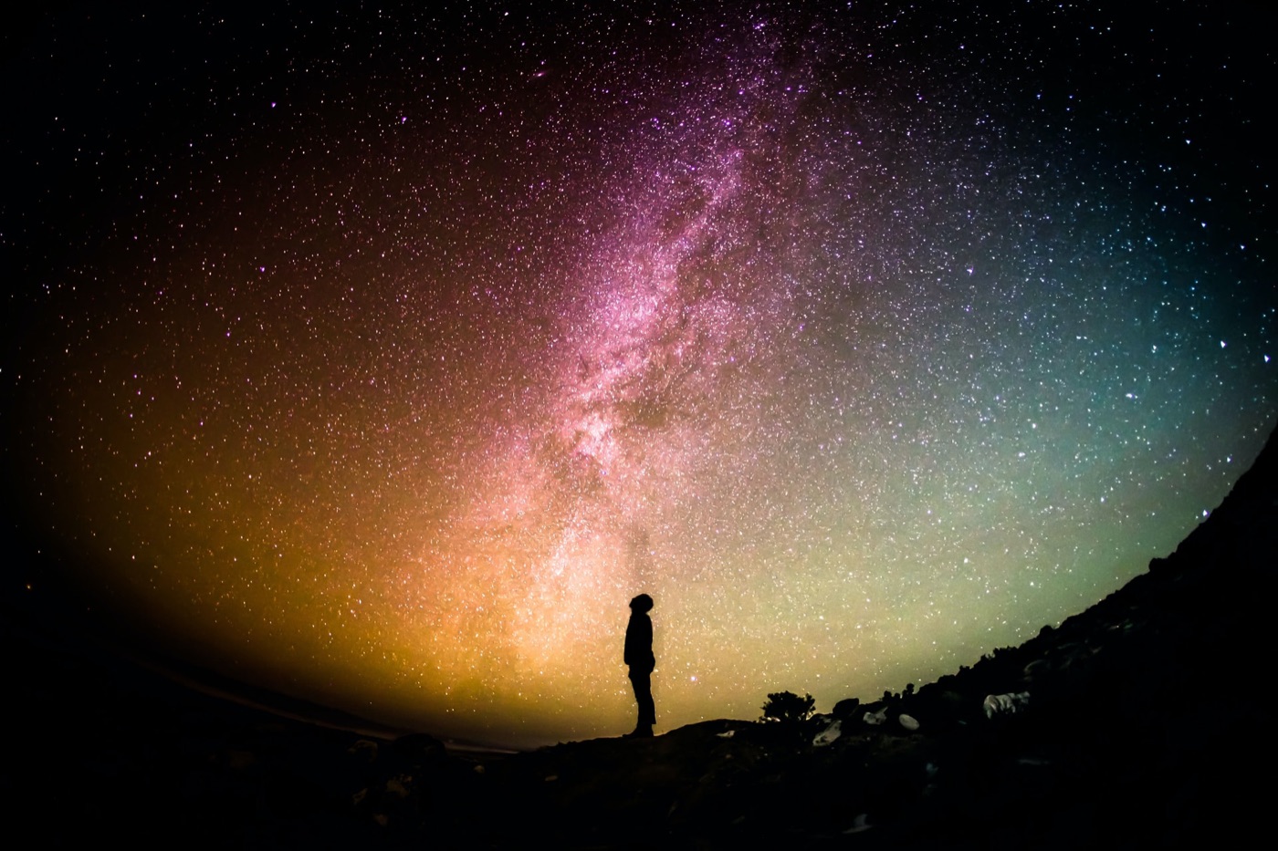 A lone figure standing under the Milky Way